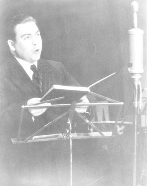 Historisches Bild von Alfons Fügel wie er in ein Migrofon singt