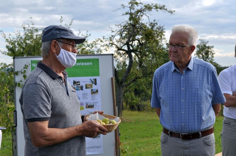 Streuobstwiesen-Experte erklärt Winfried Kretschmann die unterschiedlichen Apflesorten
