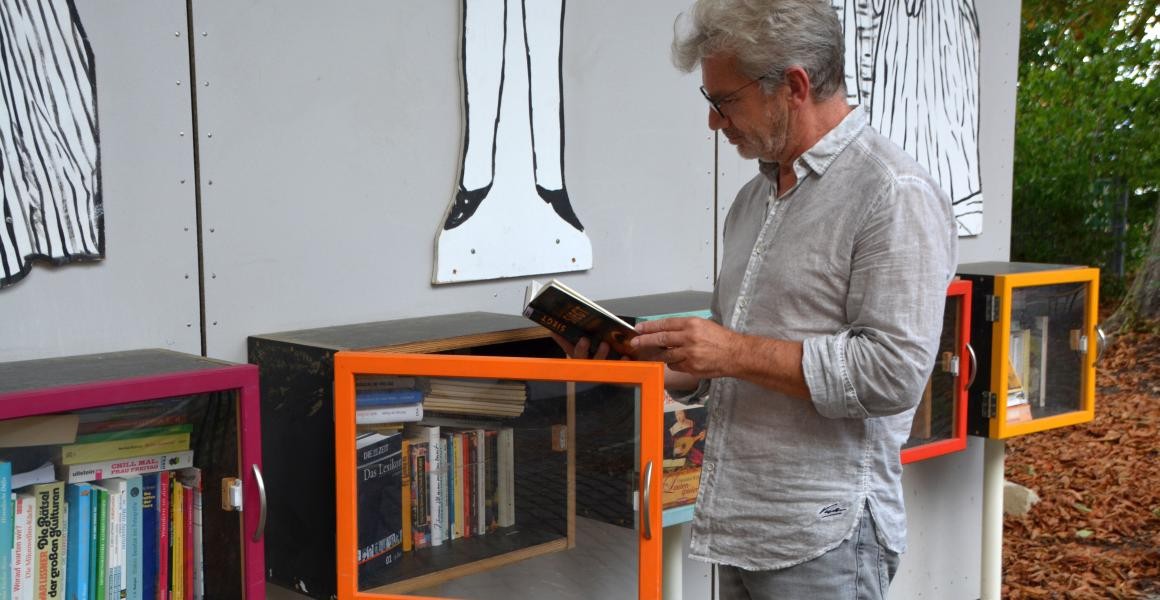 Ein Mann schaut sich die Bücher in den Schaukästen an.