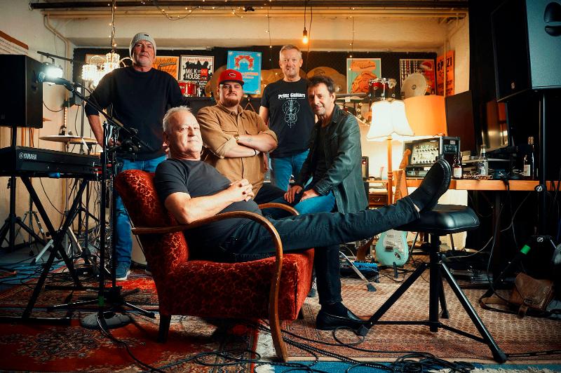 Die Band posiert im Probenraum für das Gruppenfoto