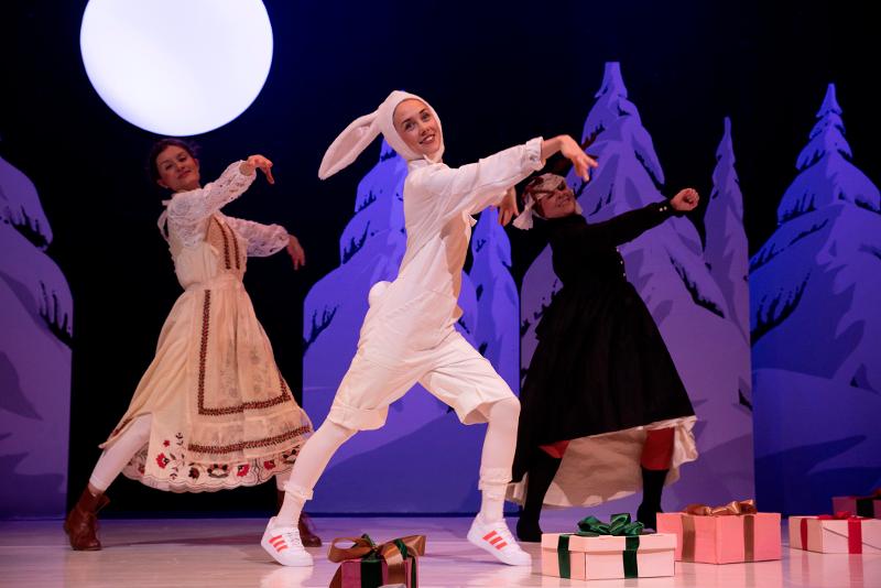 Drei Schauspielerinnen tanzen auf der Bühne. Zwei davon haben ein mittelalterliches Kleid an, die Frau im Vordergrund trägt ein Hasenkostüm.