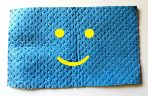 Ein blauer Wischlappen auf dem ein gelber Smily zu sehen ist